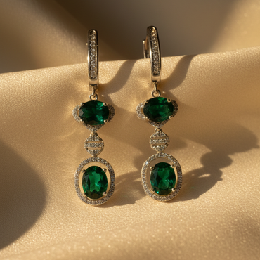 Sterling silver green emerald and white diamond double halo drop earrings on cream satin