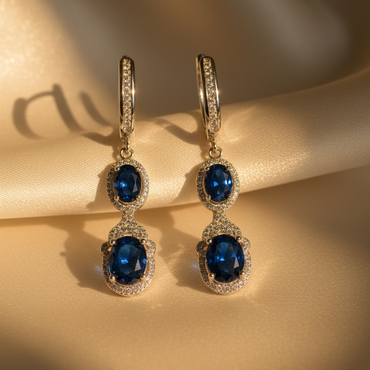 Close-up of sterling silver blue sapphire and diamond halo drop earrings