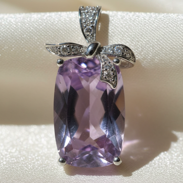 14K White Gold Cushion Amethyst and Diamond Bow Pendant - close-up detail on cream satin