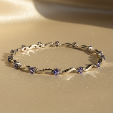 14K white gold tanzanite and diamond wave bracelet full length showing all 9 oval tanzanite stations with diamond accents
