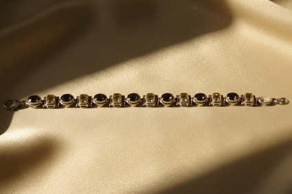 Sterling silver smoky quartz and citrine alternating link bracelet on cream satin, editorial luxury photography