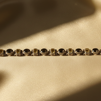 Sterling silver smoky quartz and citrine alternating link bracelet on cream satin, editorial luxury photography