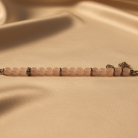Sterling silver rose quartz and CZ heart charm toggle bracelet on cream satin, editorial luxury photography