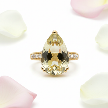 Pear-cut lime quartz ring front facing view with white and pink rose petals