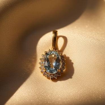 14K Yellow Gold Oval Aquamarine and Diamond Halo Enhancer Pendant - angled view on cream satin