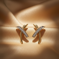 14K Yellow Gold Diamond Wishbone X-Cross Earrings on champagne gold silk backdrop editorial marketing image