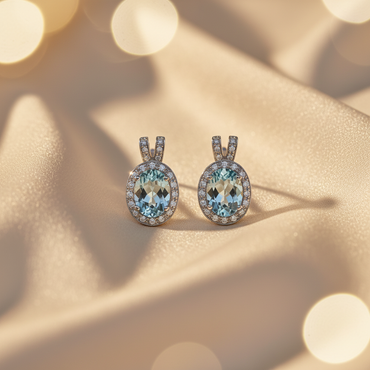 14K White Gold Oval Aquamarine Diamond Halo Omega Back Earrings on cream satin