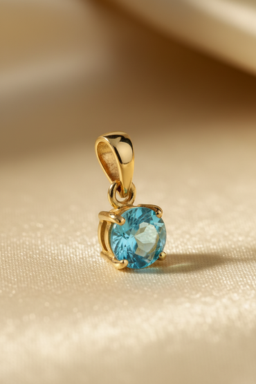 14K yellow gold round blue topaz solitaire pendant, three-quarter angle