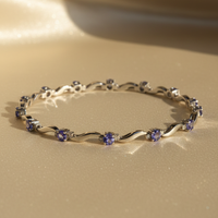 14K white gold tanzanite and diamond wave bracelet full length showing all 9 oval tanzanite stations with diamond accents