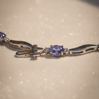 14K white gold tanzanite and diamond wave bracelet clasp end detail showing oval tanzanite station and box clasp