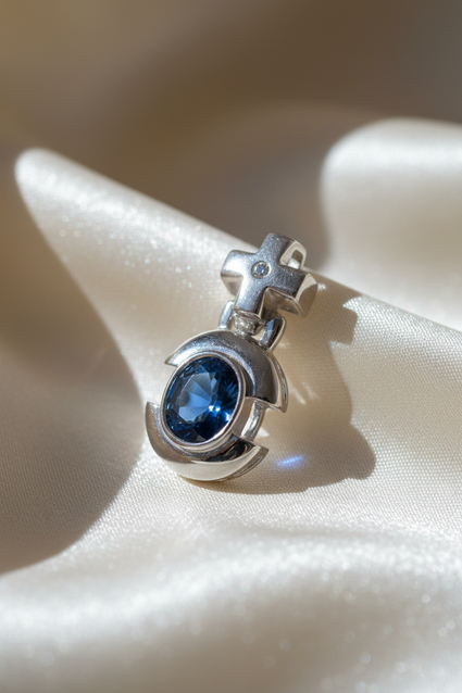 14K white gold oval blue sapphire and diamond cross bail pendant, three-quarter angle