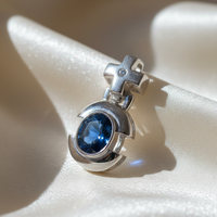 14K white gold oval blue sapphire and diamond cross bail pendant, three-quarter angle