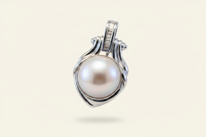 14K white gold mabe pearl and baguette diamond pendant floating on ivory backdrop luxury editorial marketing image