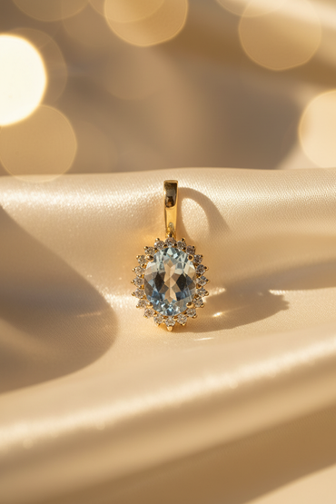 14K Yellow Gold Oval Aquamarine and Diamond Halo Enhancer Pendant - front view on cream satin