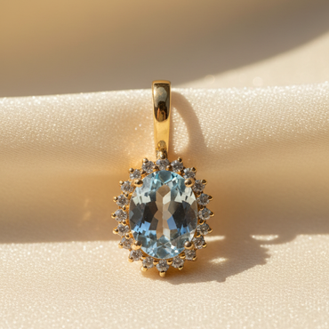 14K Yellow Gold Oval Aquamarine and Diamond Halo Enhancer Pendant - close-up detail on cream satin