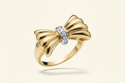 10K yellow gold diamond bow ring floating on ivory backdrop luxury editorial marketing image