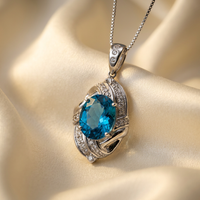 Platinum Swiss blue topaz and diamond pendant, turned view on cream satin