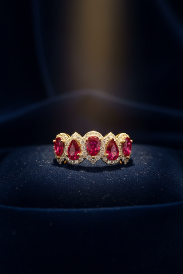 14K Yellow Gold Five-Stone Oval Ruby and Diamond Halo Ring on navy blue velvet editorial marketing image