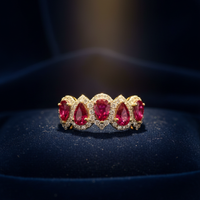 14K Yellow Gold Five-Stone Oval Ruby and Diamond Halo Ring on navy blue velvet editorial marketing image