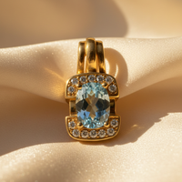 18K Yellow Gold Oval Aquamarine and Diamond Pendant - front view, 7 diamonds top and bottom, cream satin
