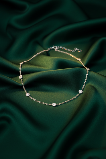 18K White Gold Diamond Daisy Station Necklace on emerald silk backdrop editorial marketing image