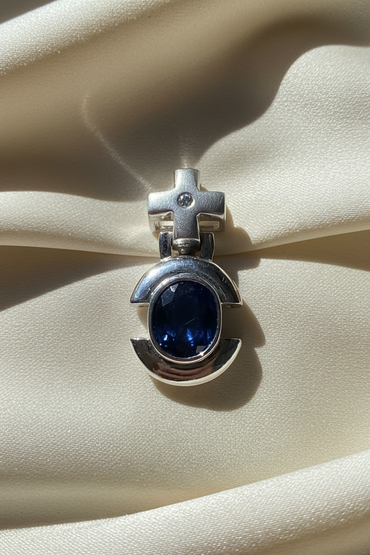 14K white gold oval blue sapphire and diamond cross bail pendant, front view