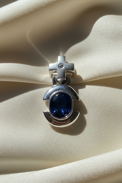 14K white gold oval blue sapphire and diamond cross bail pendant, front view