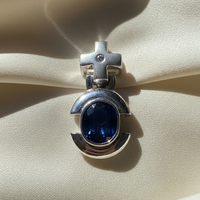 14K white gold oval blue sapphire and diamond cross bail pendant, front view