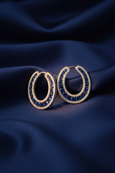 14K White Gold Blue Sapphire and Diamond Open Hoop Earrings on midnight blue silk backdrop editorial marketing image