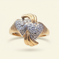 10K yellow gold double heart diamond ring floating on ivory backdrop luxury editorial marketing image